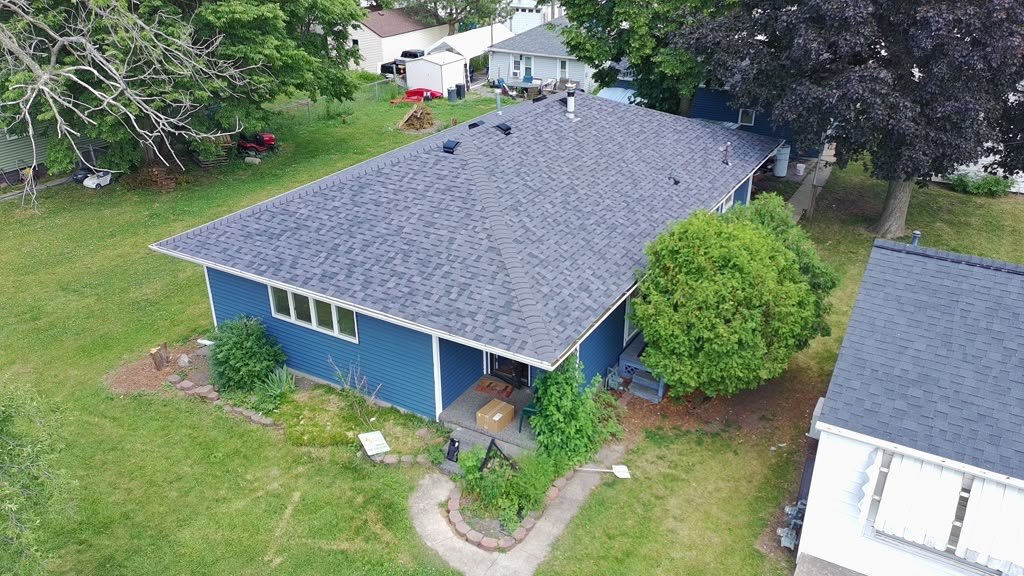 A completed Eagle Star roof in grey shingles on a blue-sided Chicagoland home