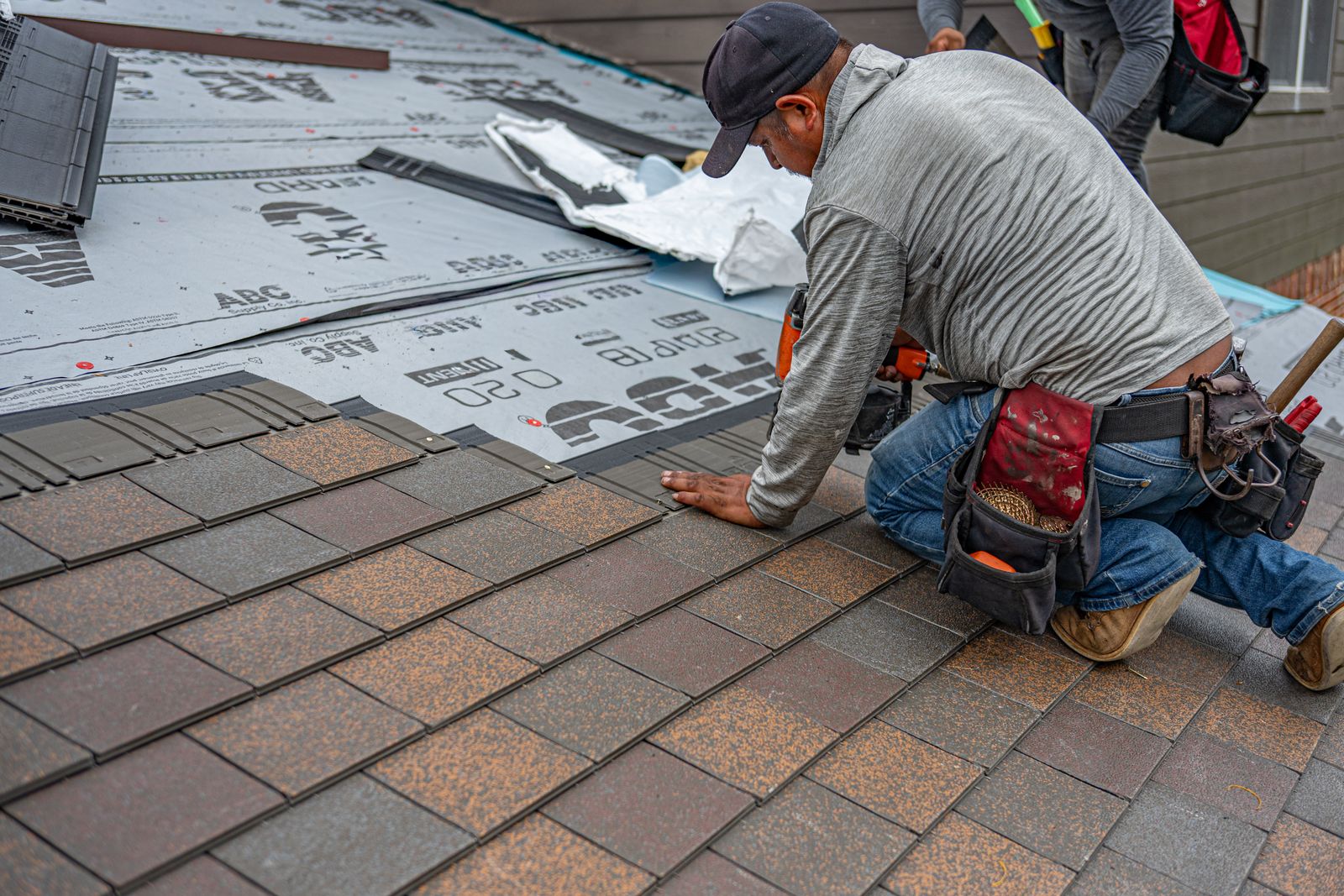 Roofing crew installing new shingles on a residential roof